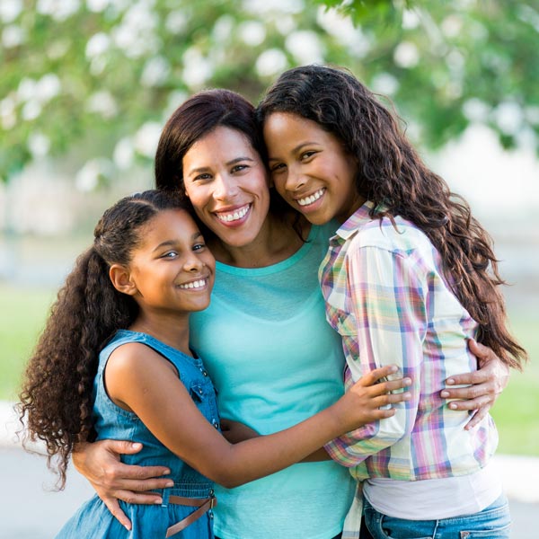 mother and two daughters smiling