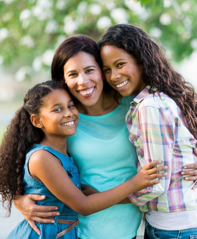 mother and two daughters smiling