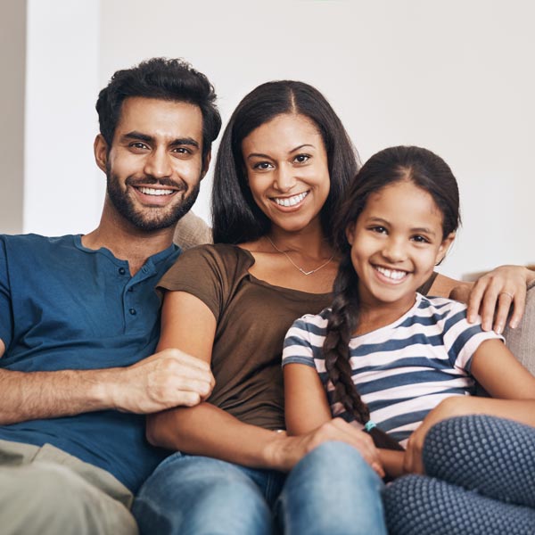 smiling family of three on couch